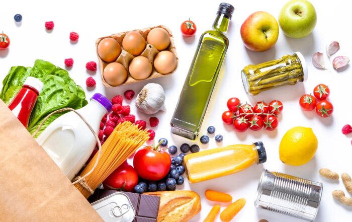 Variety of groceries spilled on white background