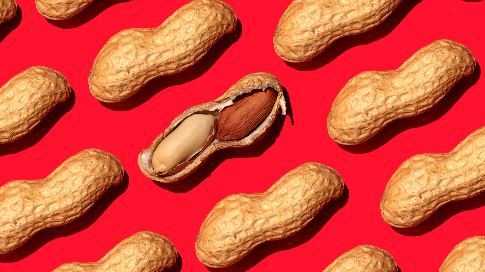 Whole peanuts on red background