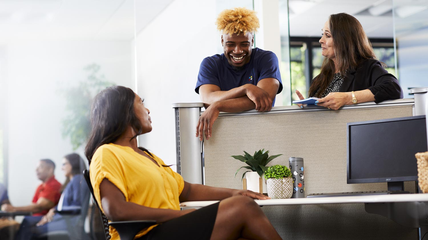 Quad employees talking around a desk