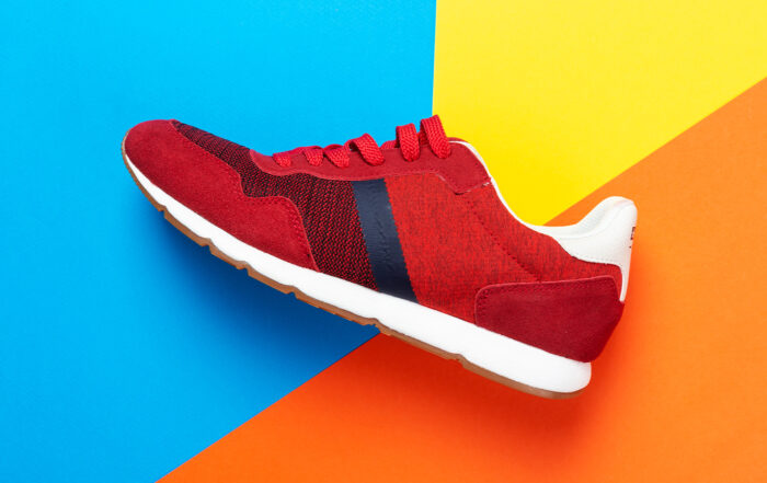 A pair of sports shoes on a colorful background. New sneakers on multi-colored background, copy space. Casual fashionable sneakers red colors.