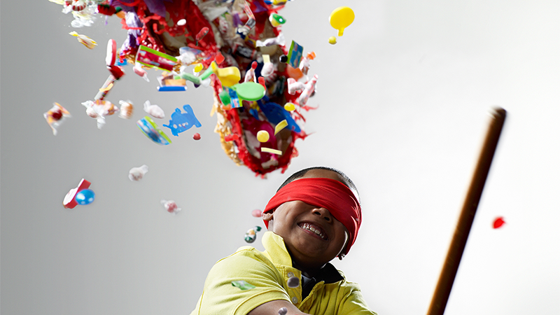 Blindfolded child smashing a piñata