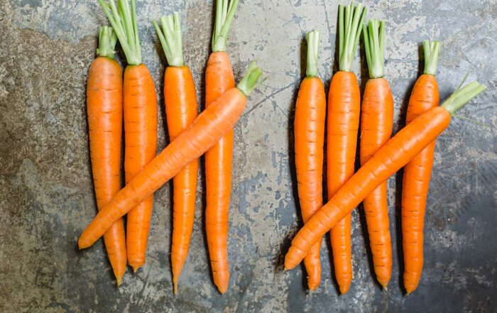 10 carrots arranged in two groups on gray surface