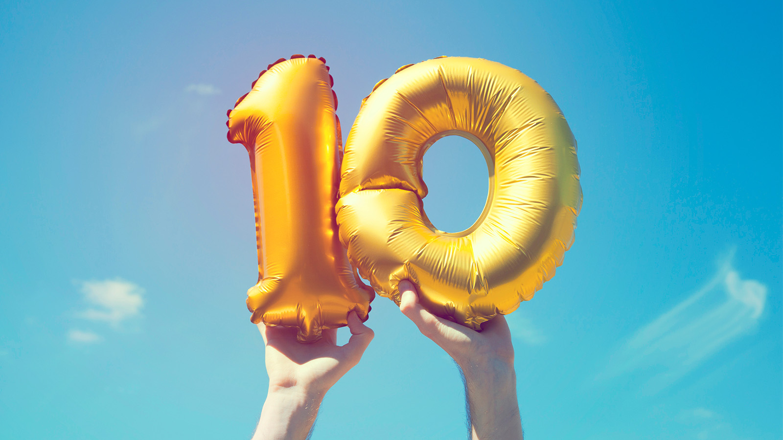 Hands holding a number ten balloon