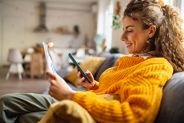 Person scanning a direct mail Flowcode while sitting in their living room